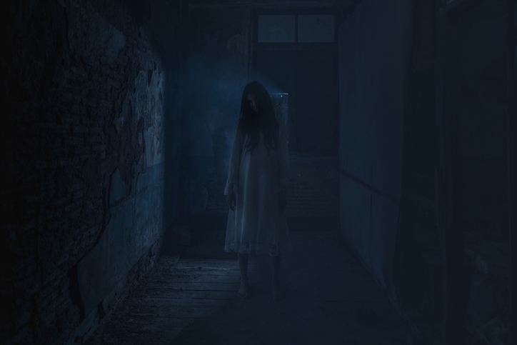Silhouetted figure standing in a dimly lit alleyway with mist, creating a eerie atmosphere