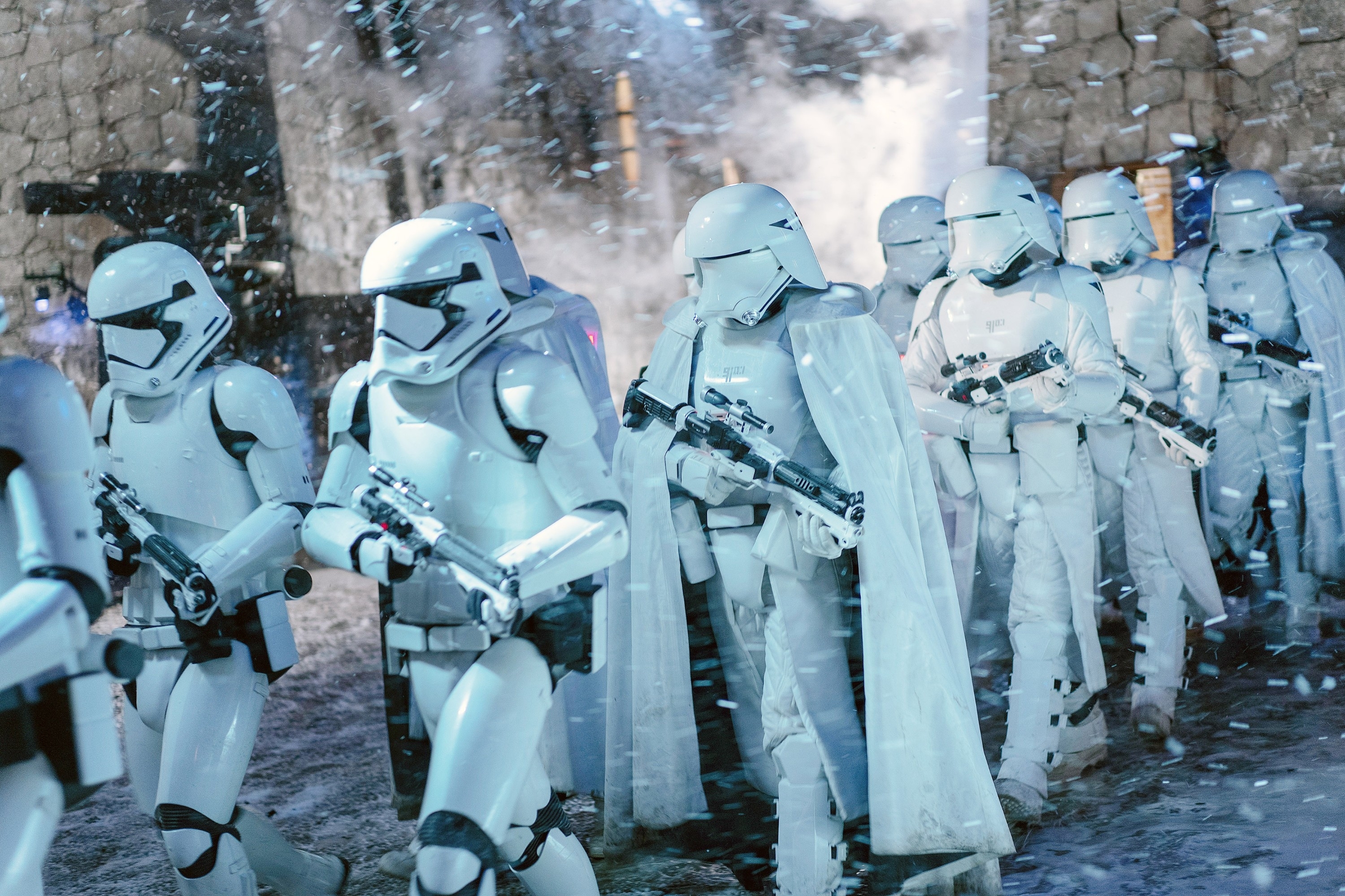 Group of Stormtroopers from Star Wars advancing in formation, with blasters ready, in a snowy setting