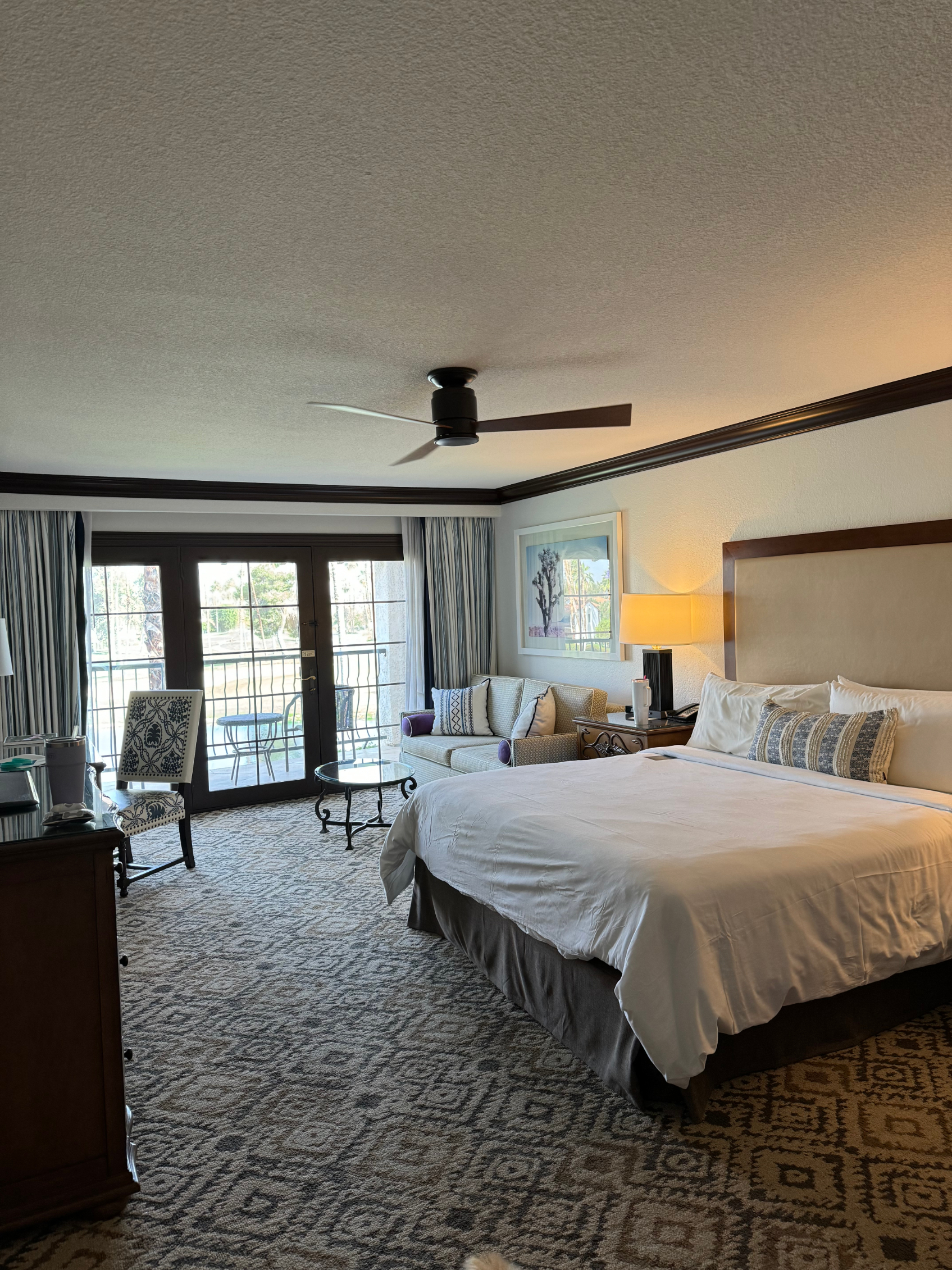 Hotel room with a bed, desk, and balcony access, illustrating lodging in a travel article