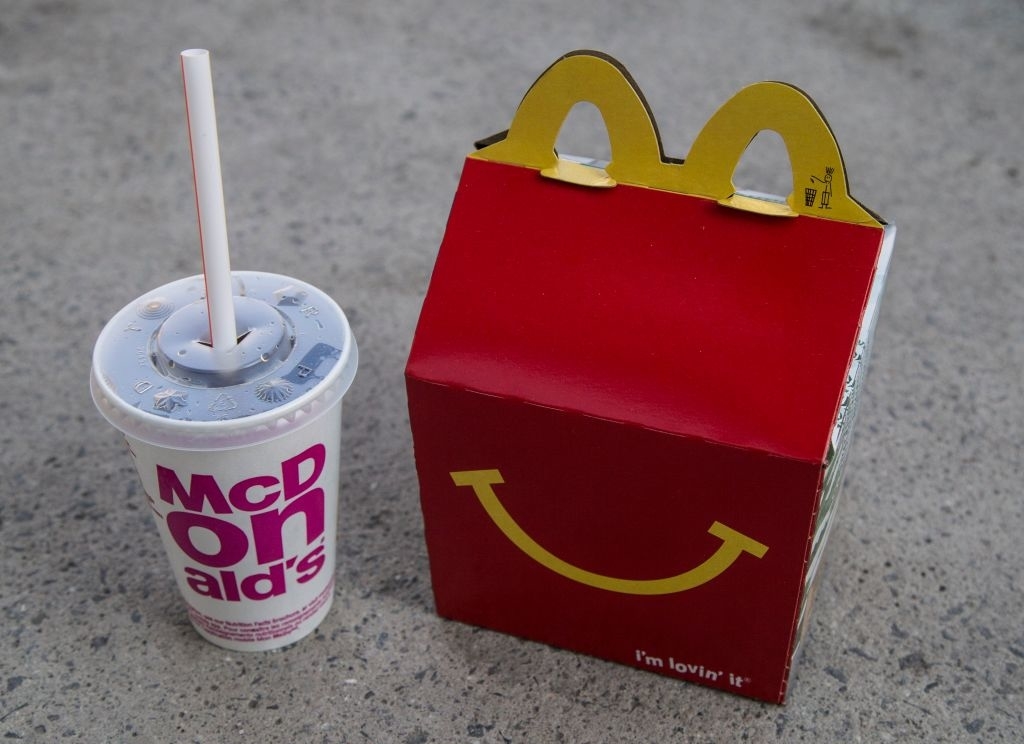 McDonald&#x27;s Happy Meal box with a drink on pavement