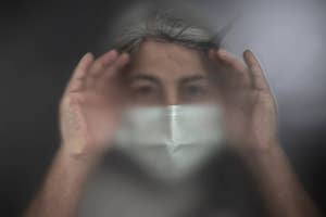 Person with obscured face holding transparent material, creating an illusionary effect