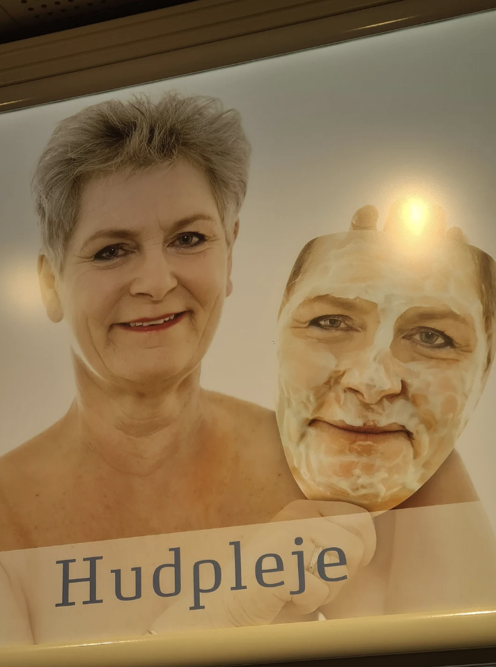 Woman holding a mask of her own face, text below reads &quot;Hudpleje&quot; which means skincare