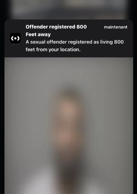 A blurred screenshot of a mobile notification about a registered offender living nearby