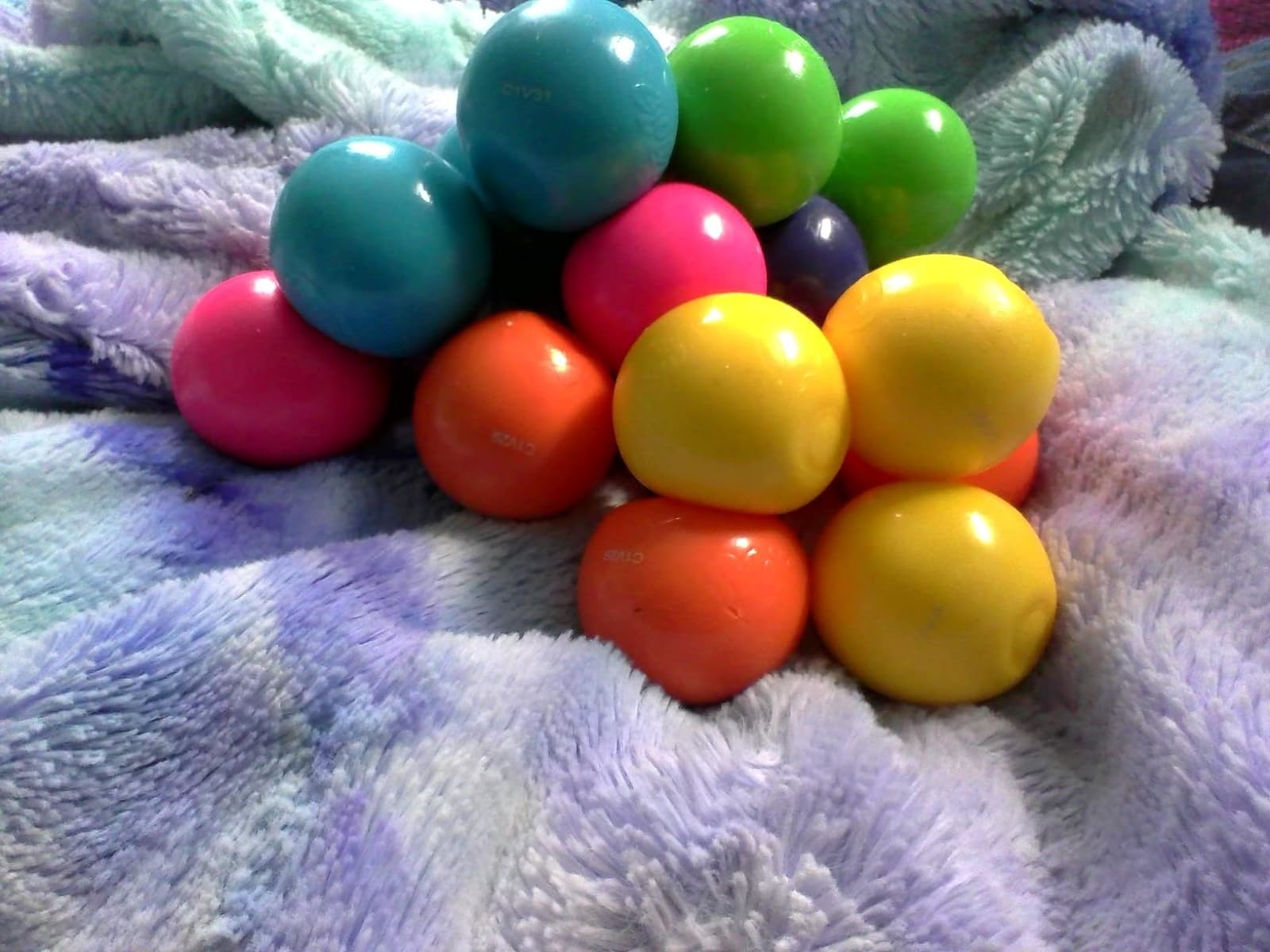 Brightly colored plastic balls on a textured blanket