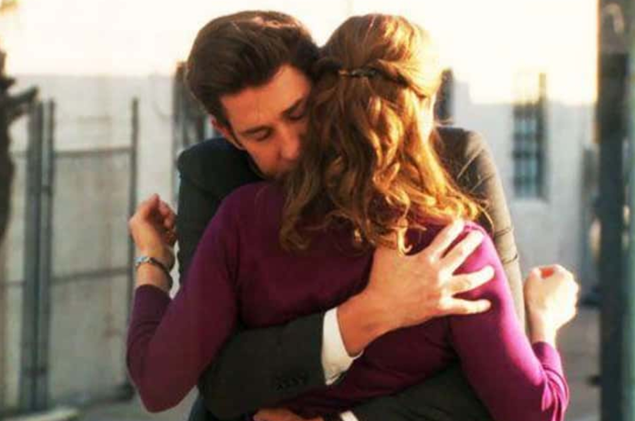 Two people are engaged in a warm embrace, showing affection