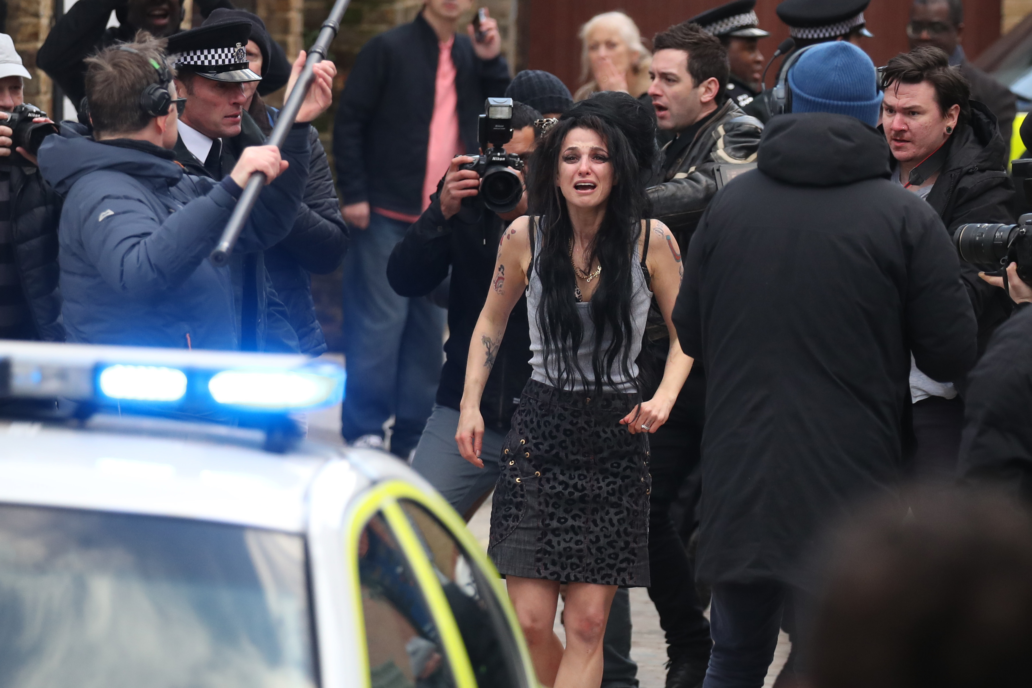 Marisa Abela as Amy Winehouse in distress, surrounded by paparazzi and police