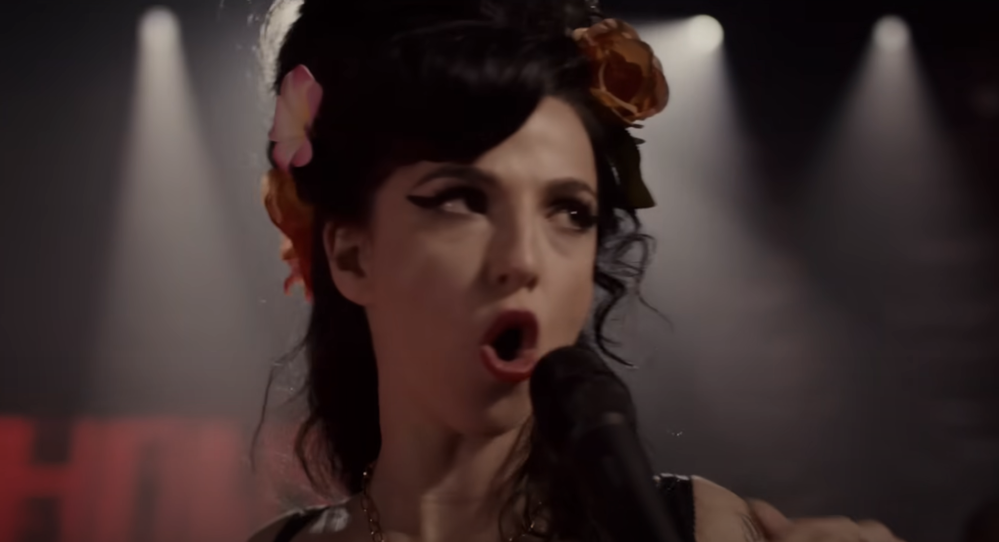 Marisa Abela as Amy Winehouse singing onstage