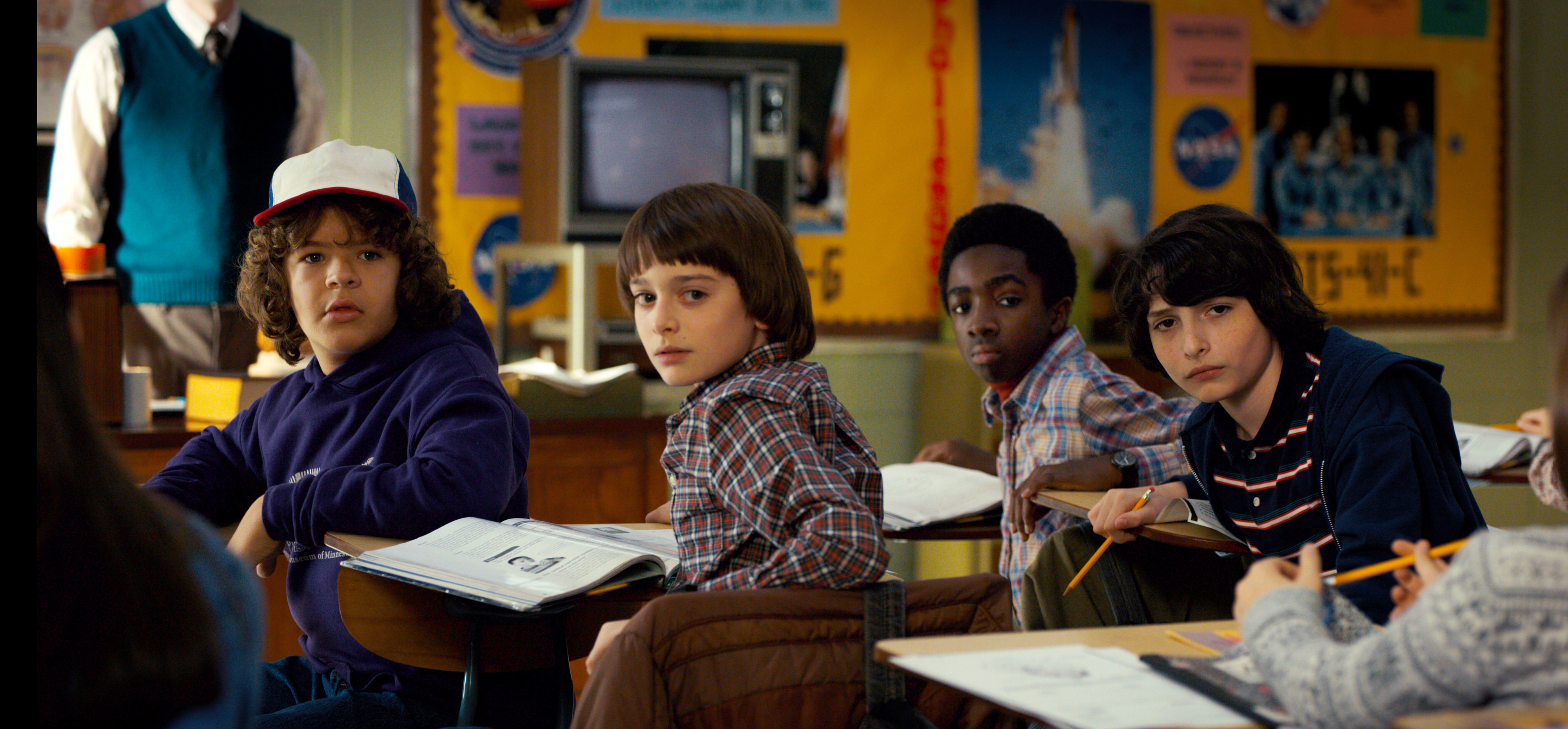 Dustin, Will, Lucas, and Mike from Stranger Things in a classroom scene