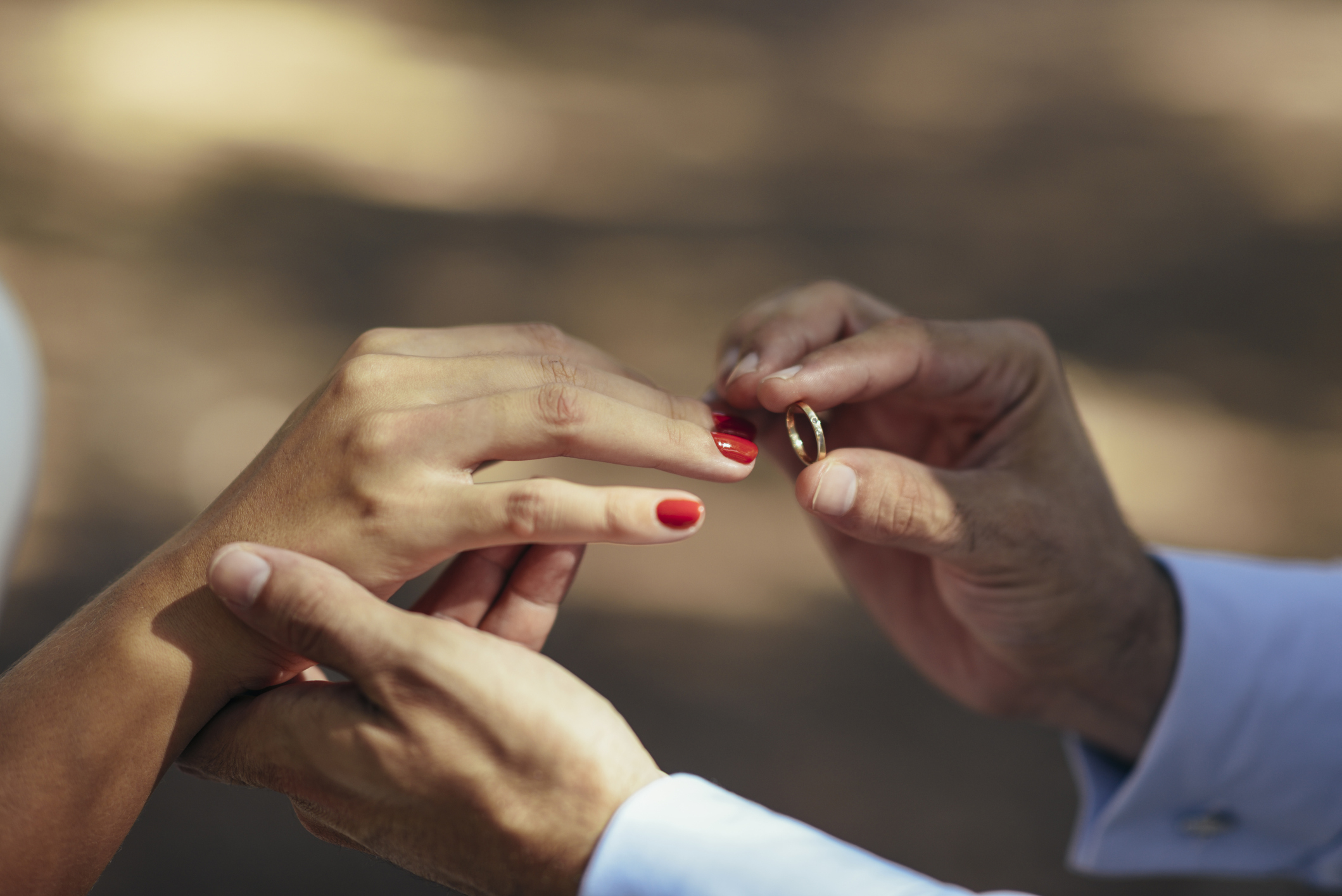 Two people exchanging rings, likely an engagement or wedding ceremony moment