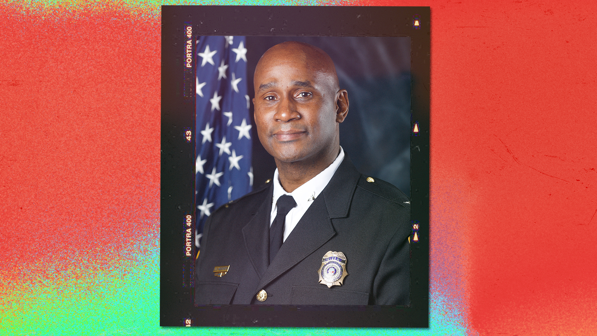 Portrait of a firefighter in uniform with badges, in front of the American flag