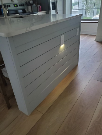 Kitchen island with horizontal lines and a small pendant light above
