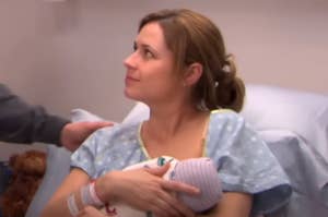 Pam from The Office holding a baby