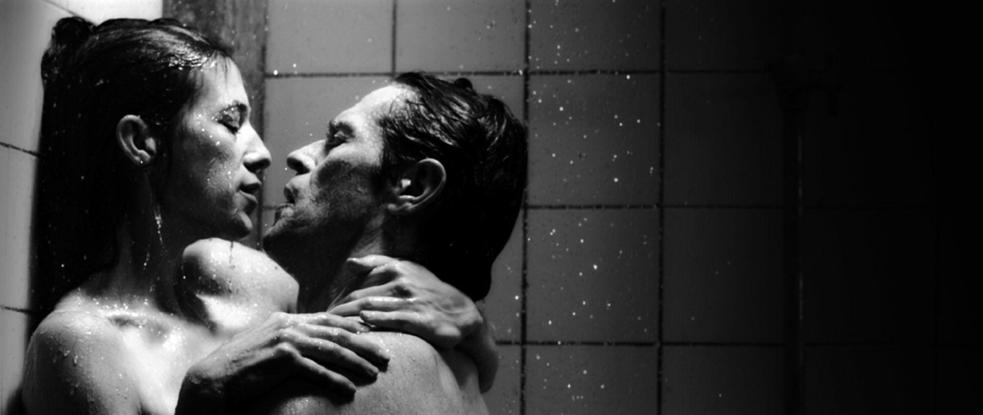 Two people embracing in a shower, facing each other intimately