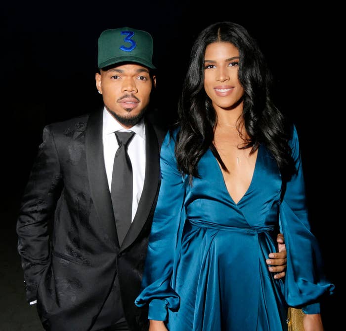 Chance the Rapper and his wife, Kirsten Corley Bennett, posing together, one in a suit with a cap, the other in a deep V-neck dress at an event