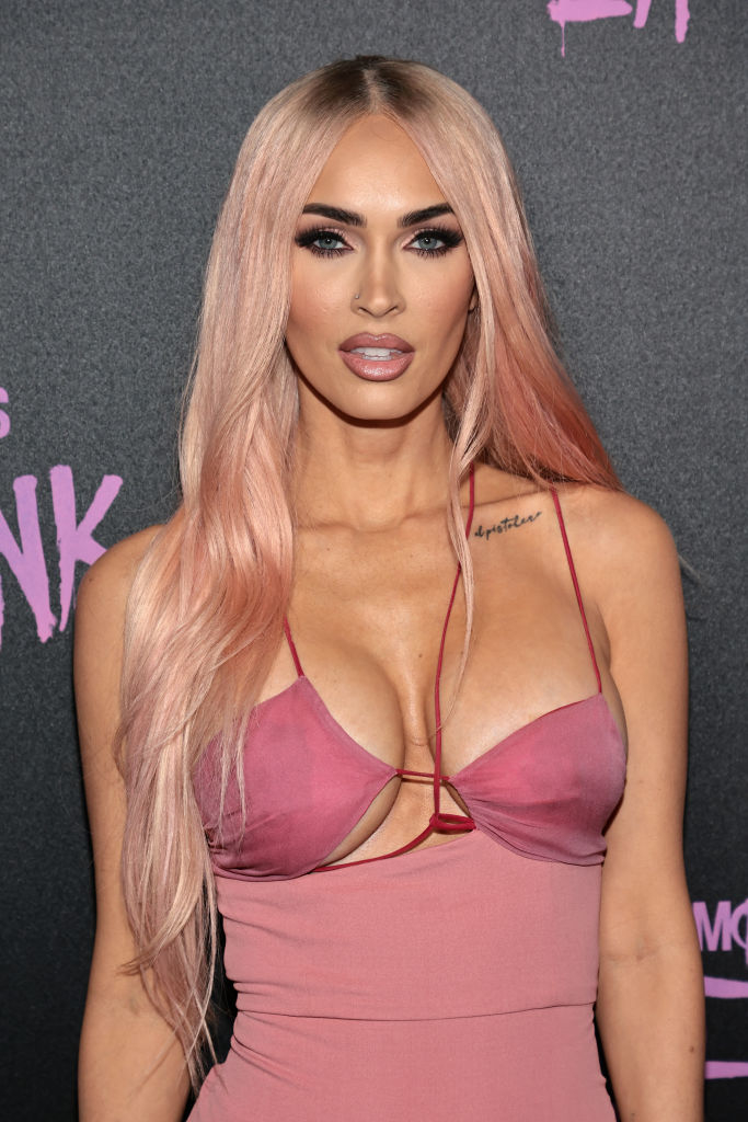 Megan Fox in a strappy pink top with a plunging neckline at an event