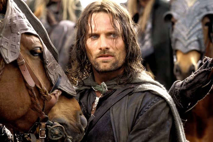 Aragorn in a battle-ready stance with armor, holding reins, and concerned expression