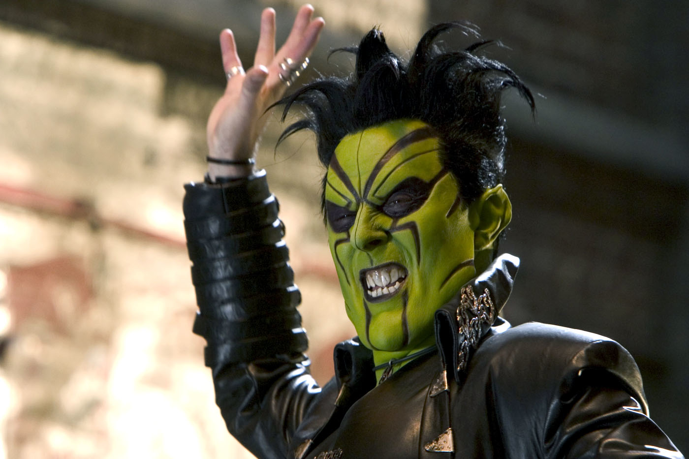 Alan Cumming with spiked hair and face paint in a scene