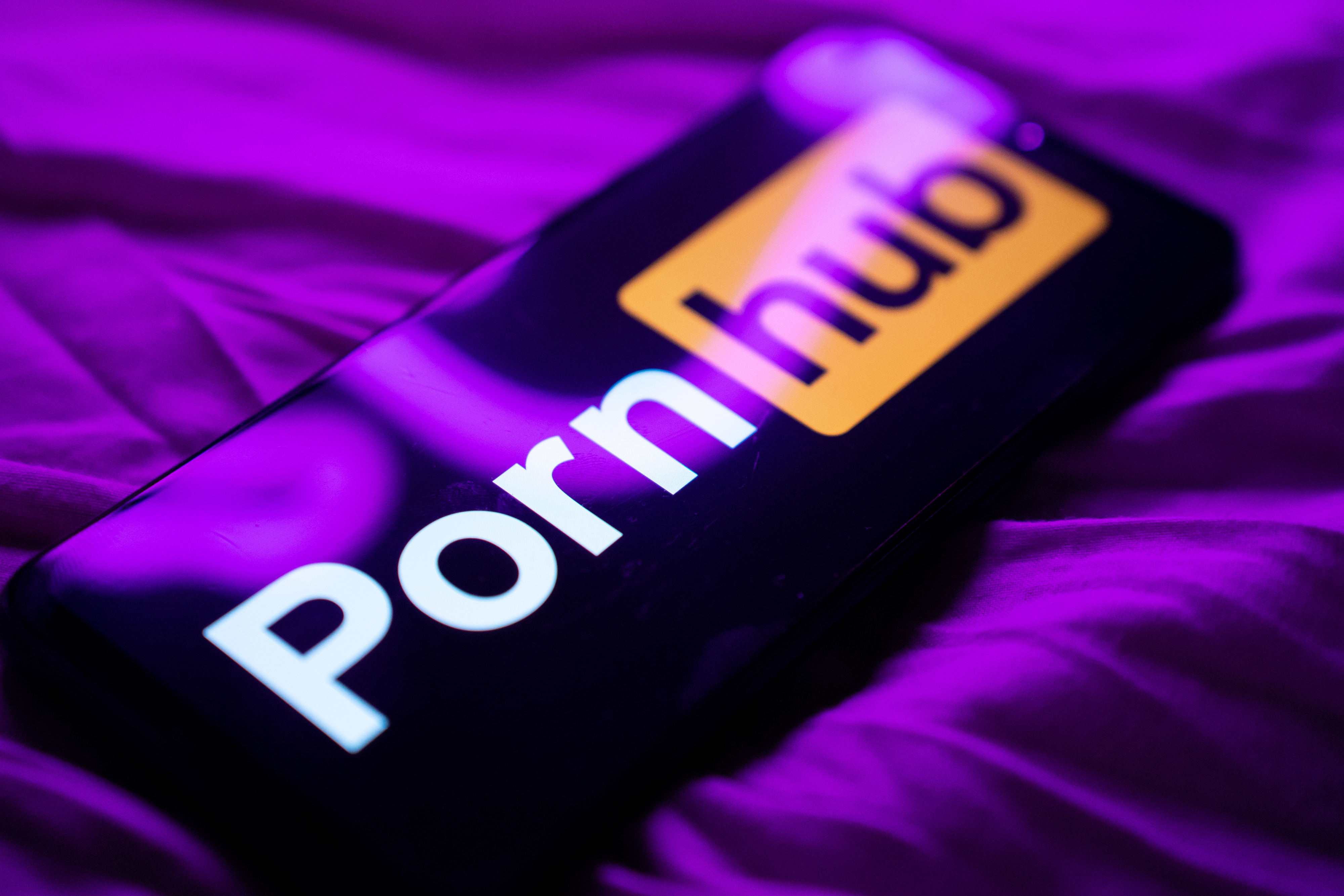 Phone screen displaying Pornhub logo on a surface