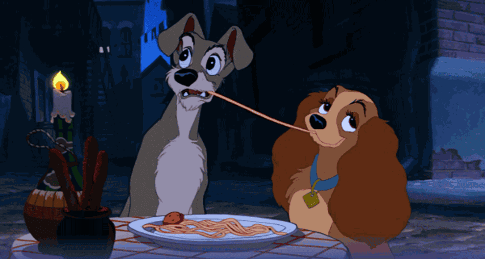 Lady and the Tramp sharing spaghetti in a romantic scene from the animated film