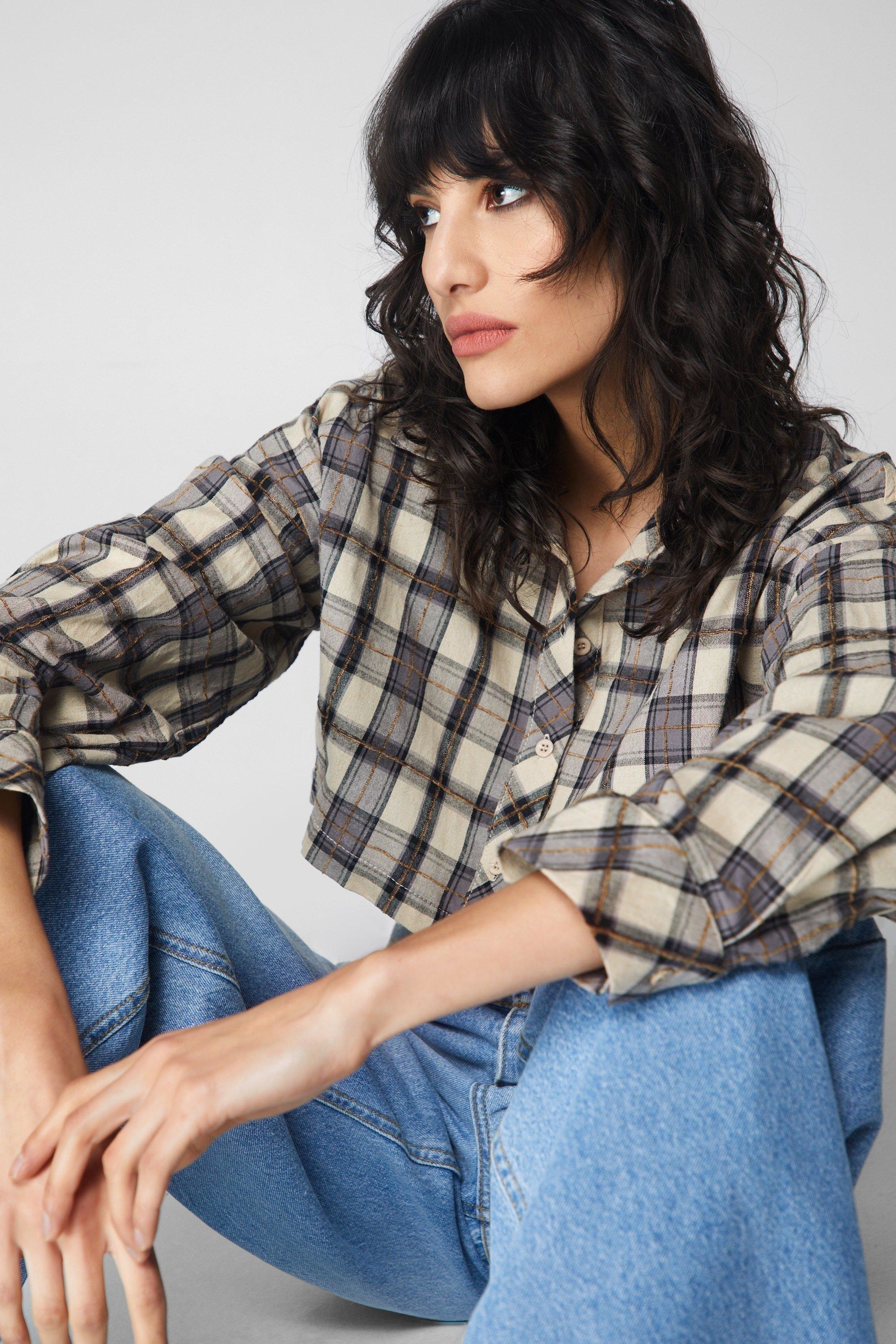 model in plaid shirt and denim jeans looking to the side