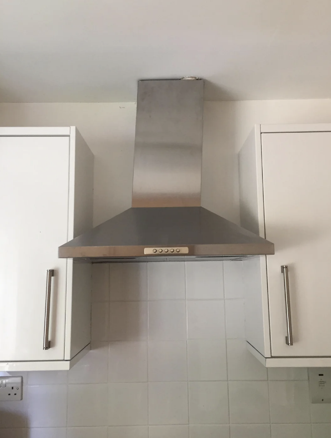 A steel range hood that&#x27;s crooked in a kitchen