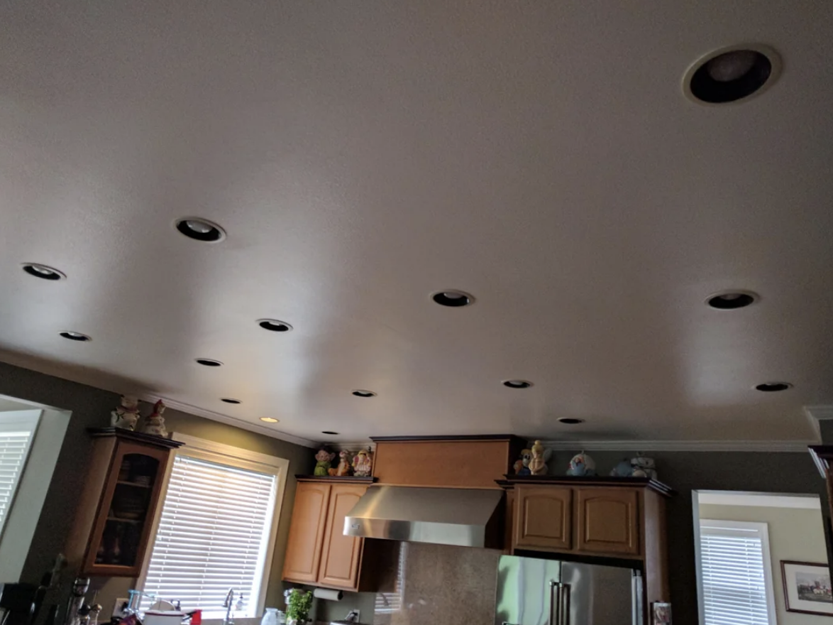 Interior view of a kitchen with recessed lighting and cabinets, some decor on top
