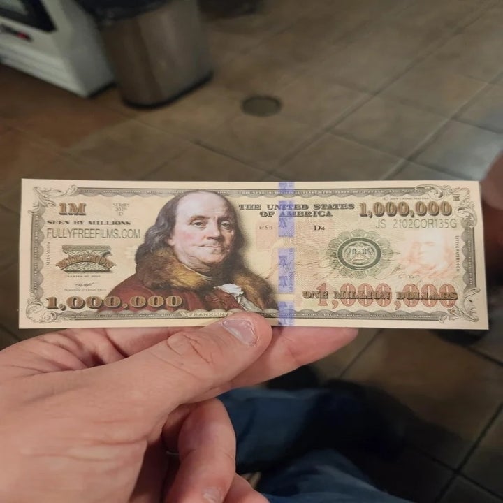Hand holding novelty $1,000,000 bill with Benjamin Franklin's image
