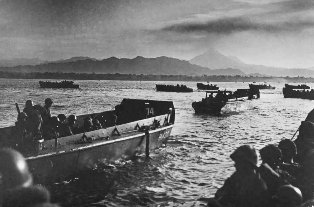 Landing crafts approach a beach with soldiers during a historical military operation