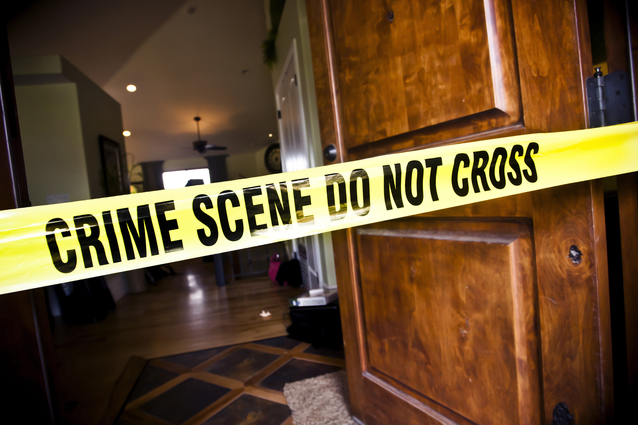 Crime scene tape across a door, indicating an investigation area inside