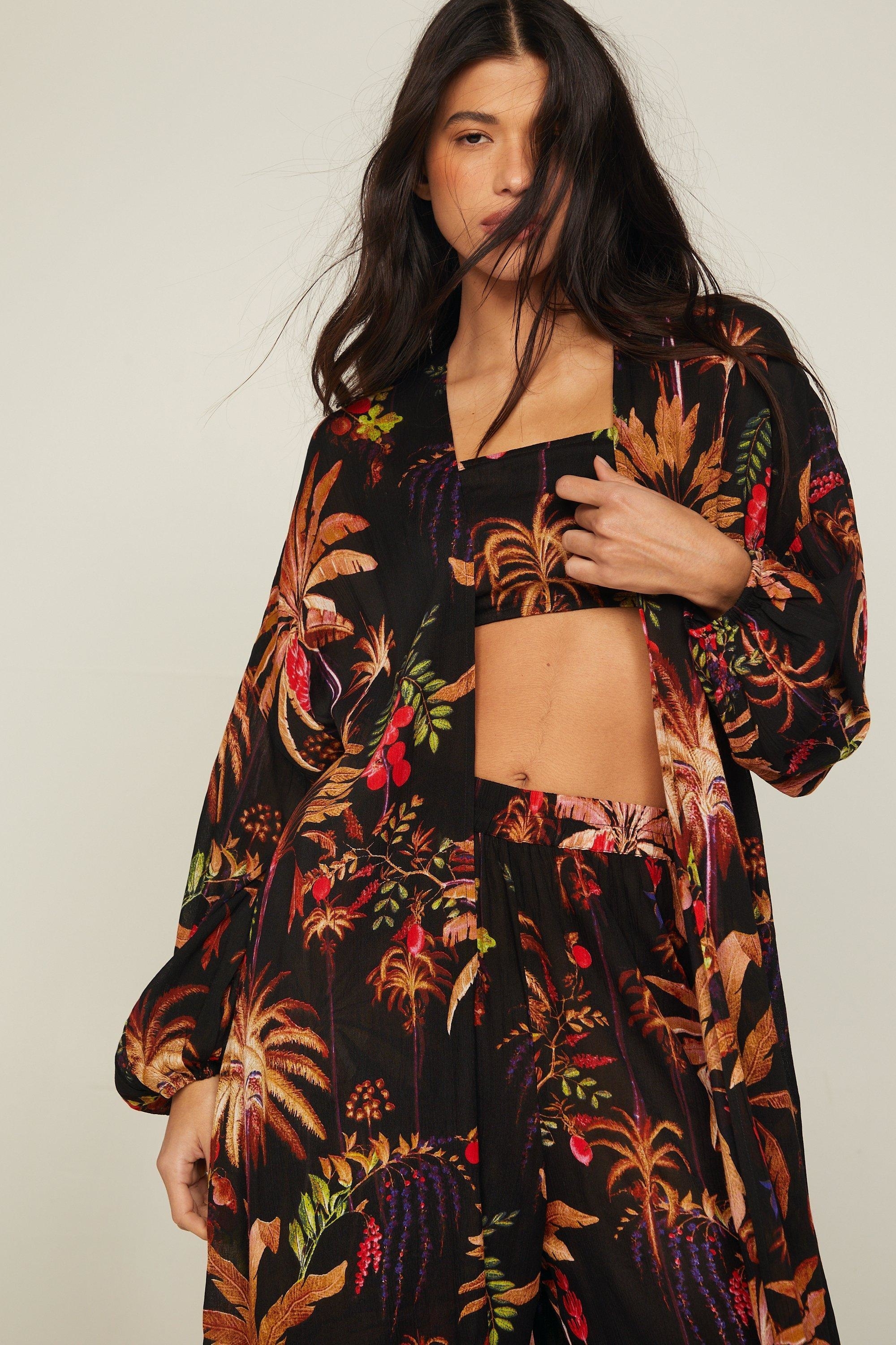 model in a tropical print three-piece outfit with midriff cutout