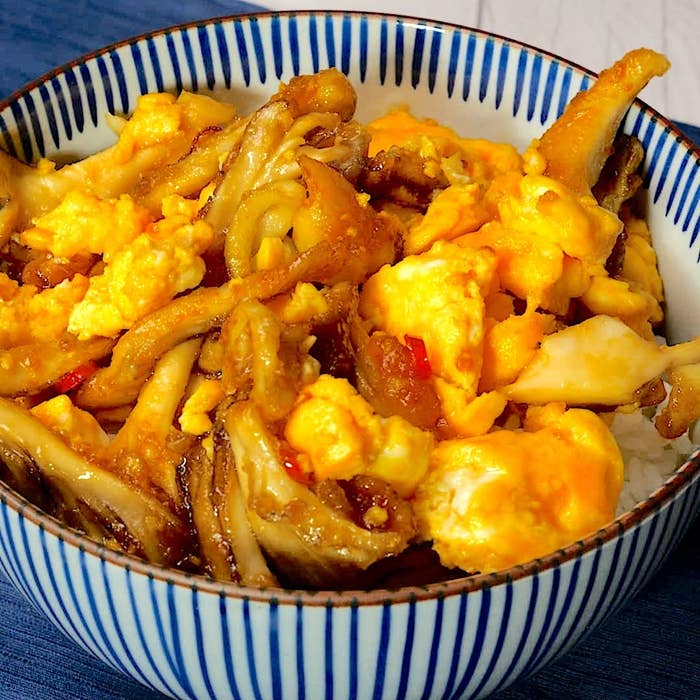 ご飯の上にまいたけと卵の炒め物が入った丼ぶりです。