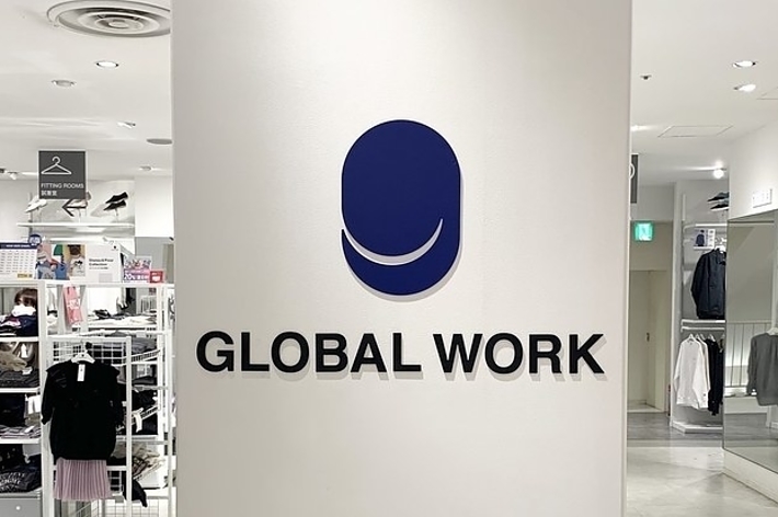店舗内にある「GLOBAL WORK」のロゴと名称が特徴的な壁面。背景には服が陳列されています。