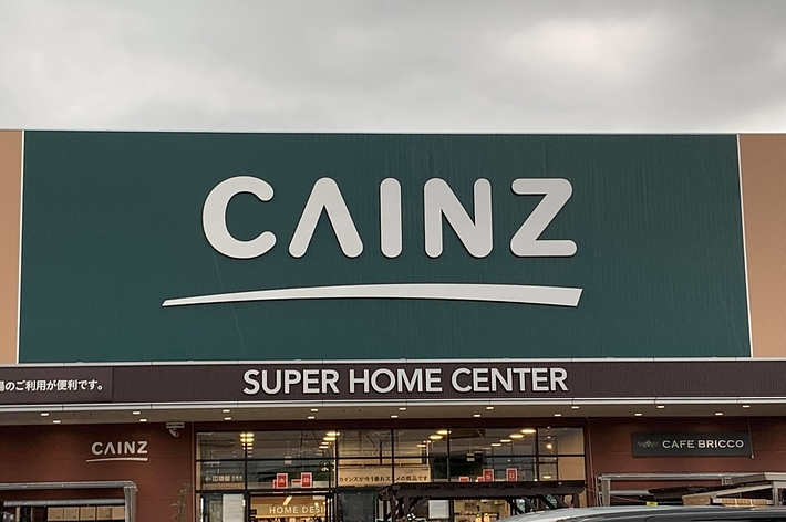 カインズホームセンターの看板があり、駐車場に車が停まっています。