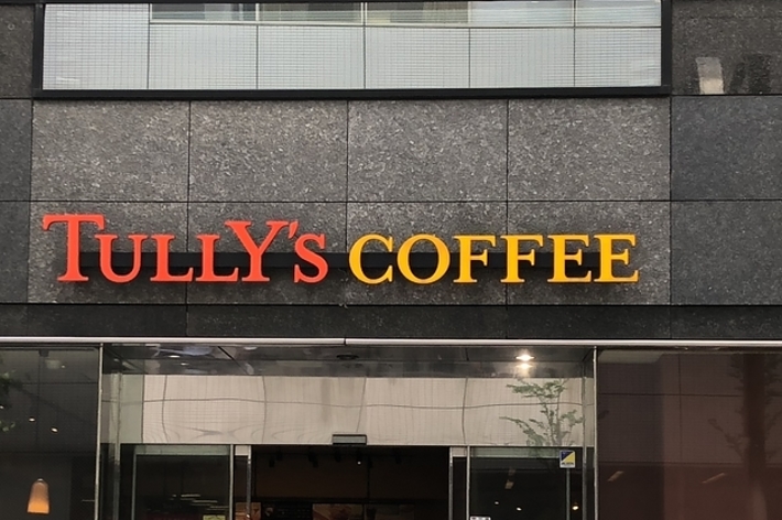 タリーズコーヒー店の外観。人々が入口近くで立ち話している。