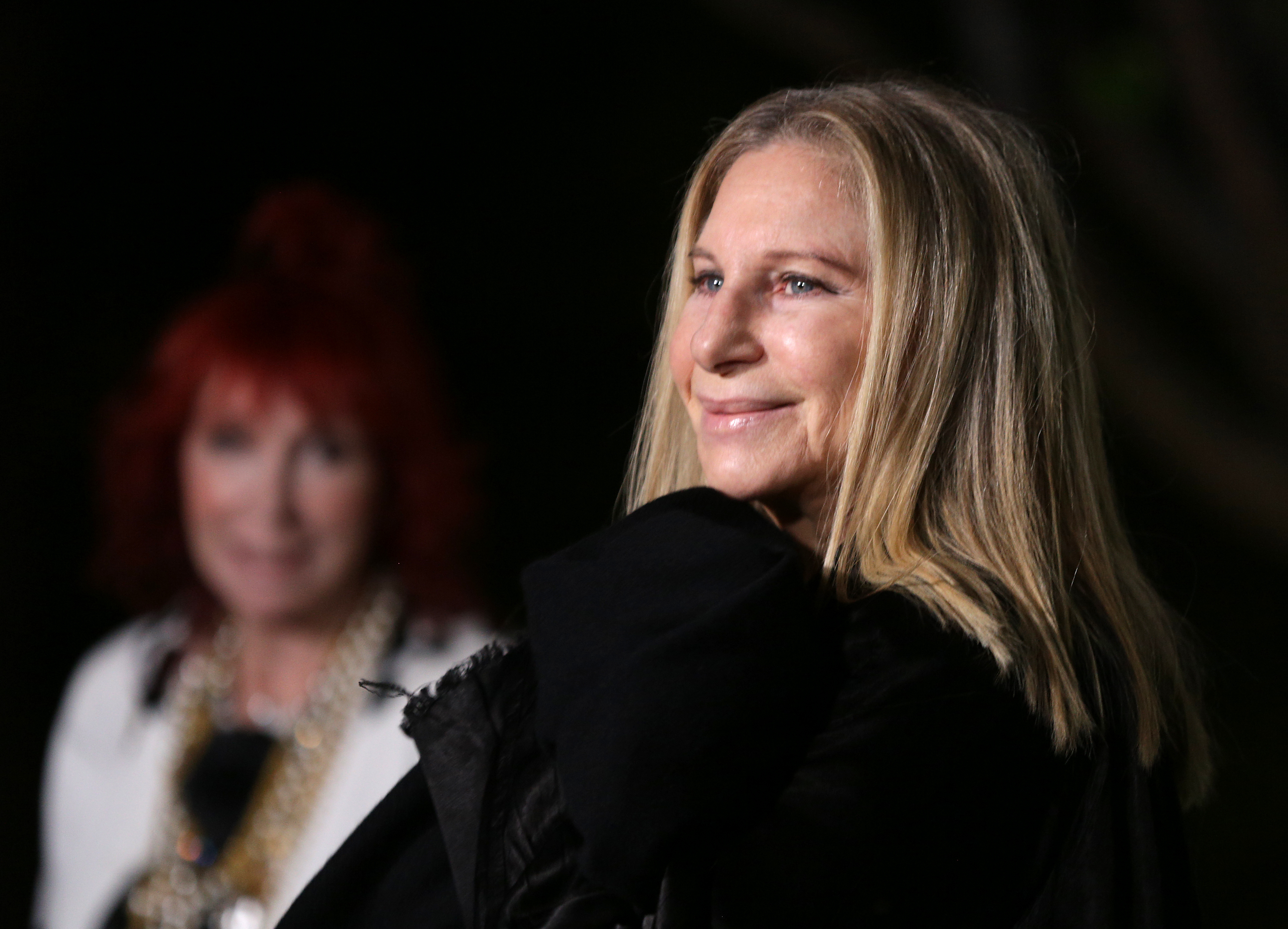 Barbra Streisand in profile wearing a black outfit at an evening event