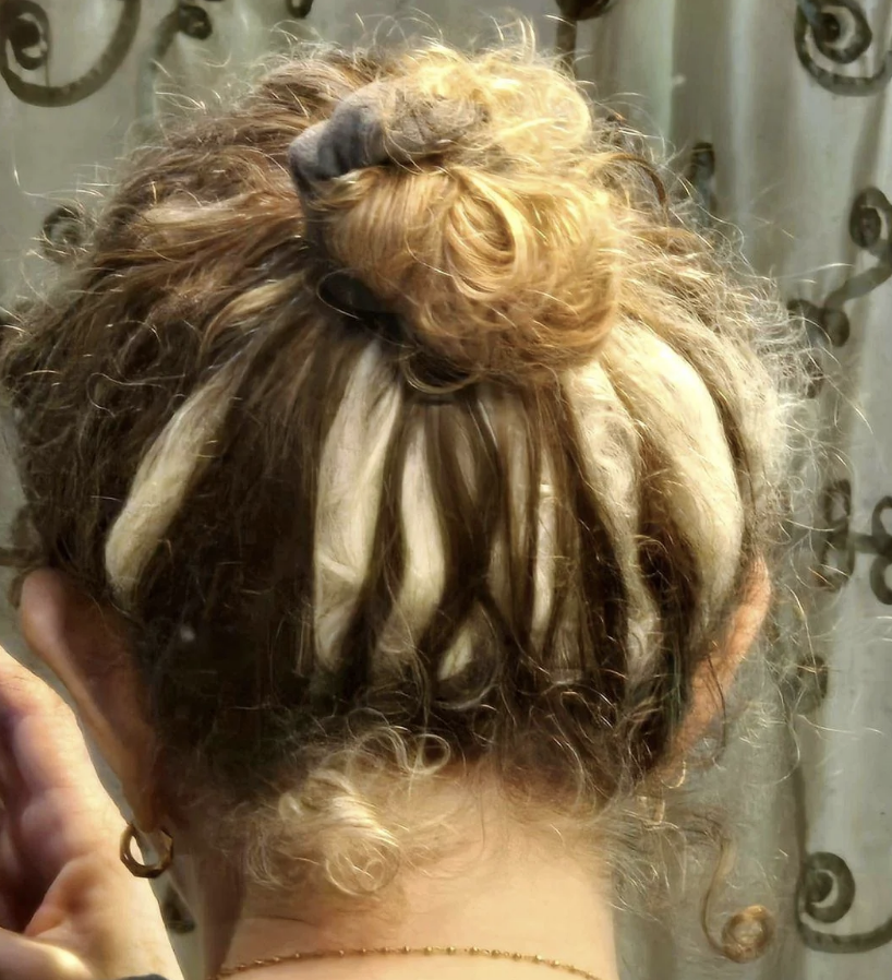 Hair styled in an updo with strands wrapped around a bun