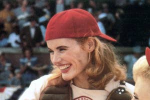 Julia Roberts in a baseball cap, white t-shirt, and vest, smiling on a movie set