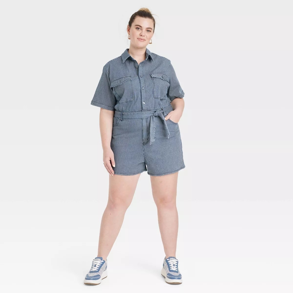 a model in the striped denim shorts jumpsuit with sash tie