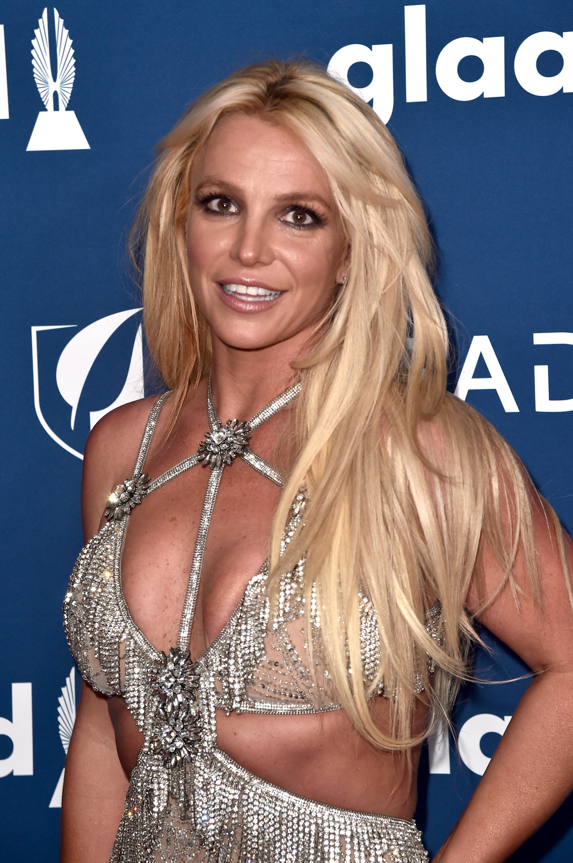 Britney Spears posing in a bejeweled dress with a plunging neckline at a glaad event