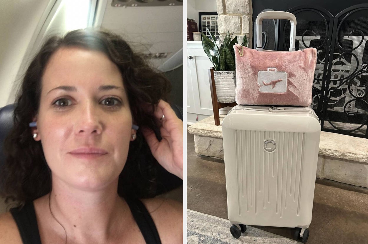 reviewer wearing silicone earplugs while sitting in plane seat; travel pillow and blanket in fleece case looped around luggage handle