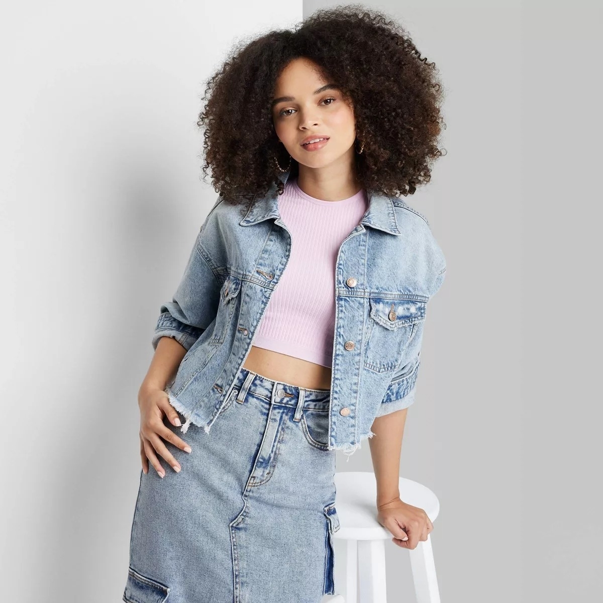 model in the cropped jacket in light wash denim