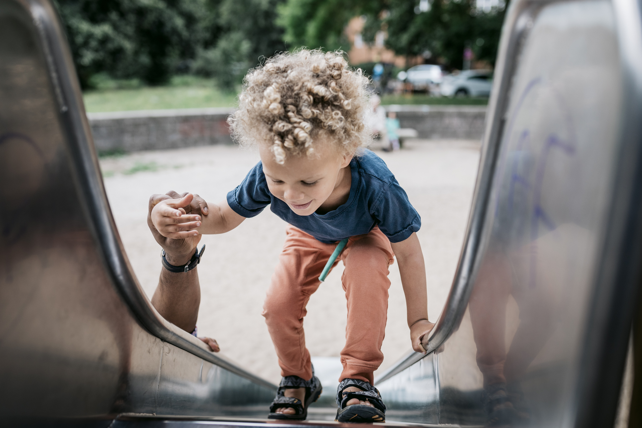 Child climbing up a slide at a playground