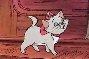 Animated kitten with a pink bow walking across a wooden floor