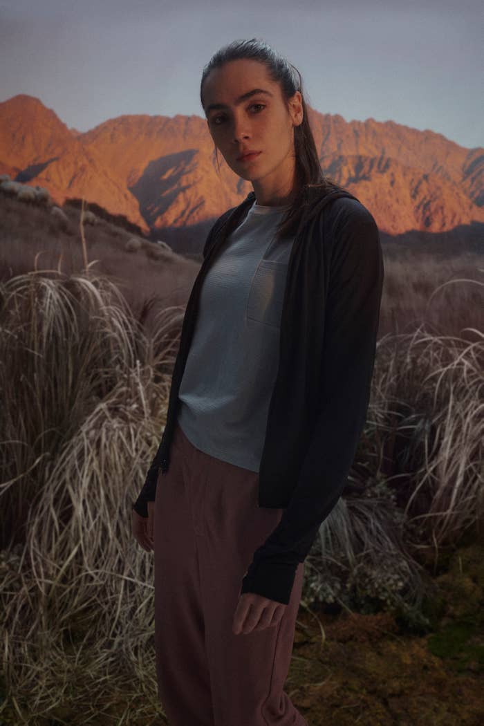 Woman in casual wear with mountains in background, suitable for outdoors. Perfect for a shopping guide on everyday attire