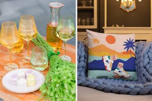 A table with wine glasses and a decorative pillow with beach design on a couch, suggesting home decor style