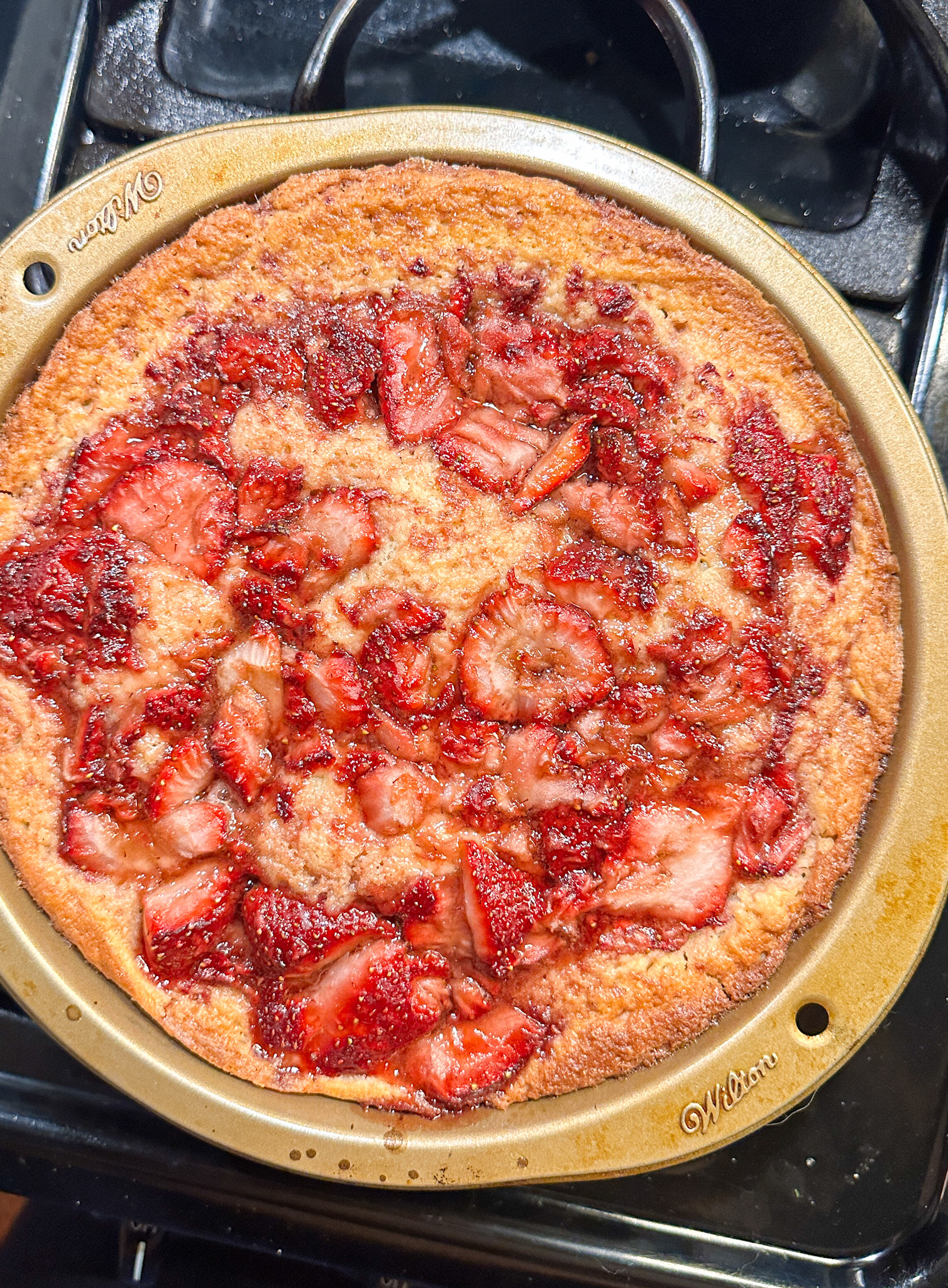 Strawberry pie with a golden-brown crust on a stove