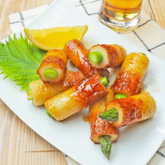 皿に盛られたちくわ巻きアスパラガス。食卓用。