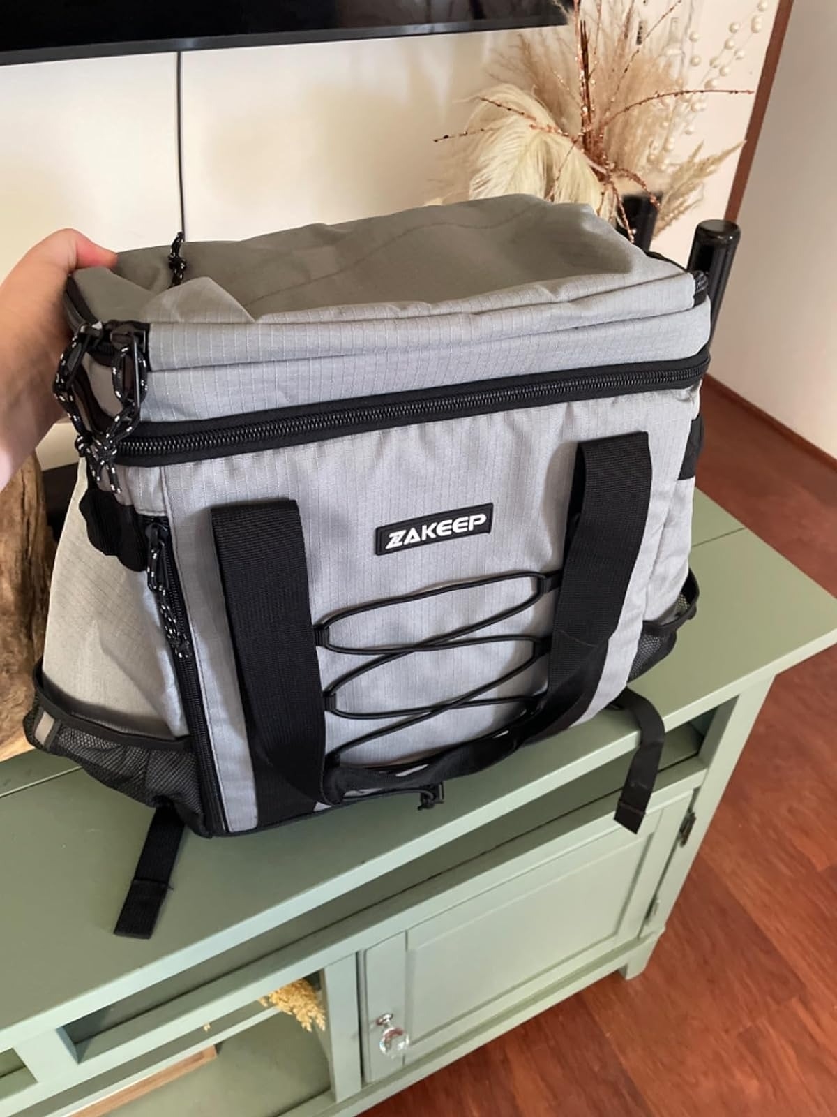 reviewer holding gray leakproof cooler backpack