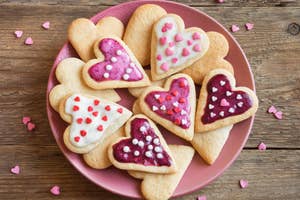 A plate with various heart- haped cookies with decorative icing