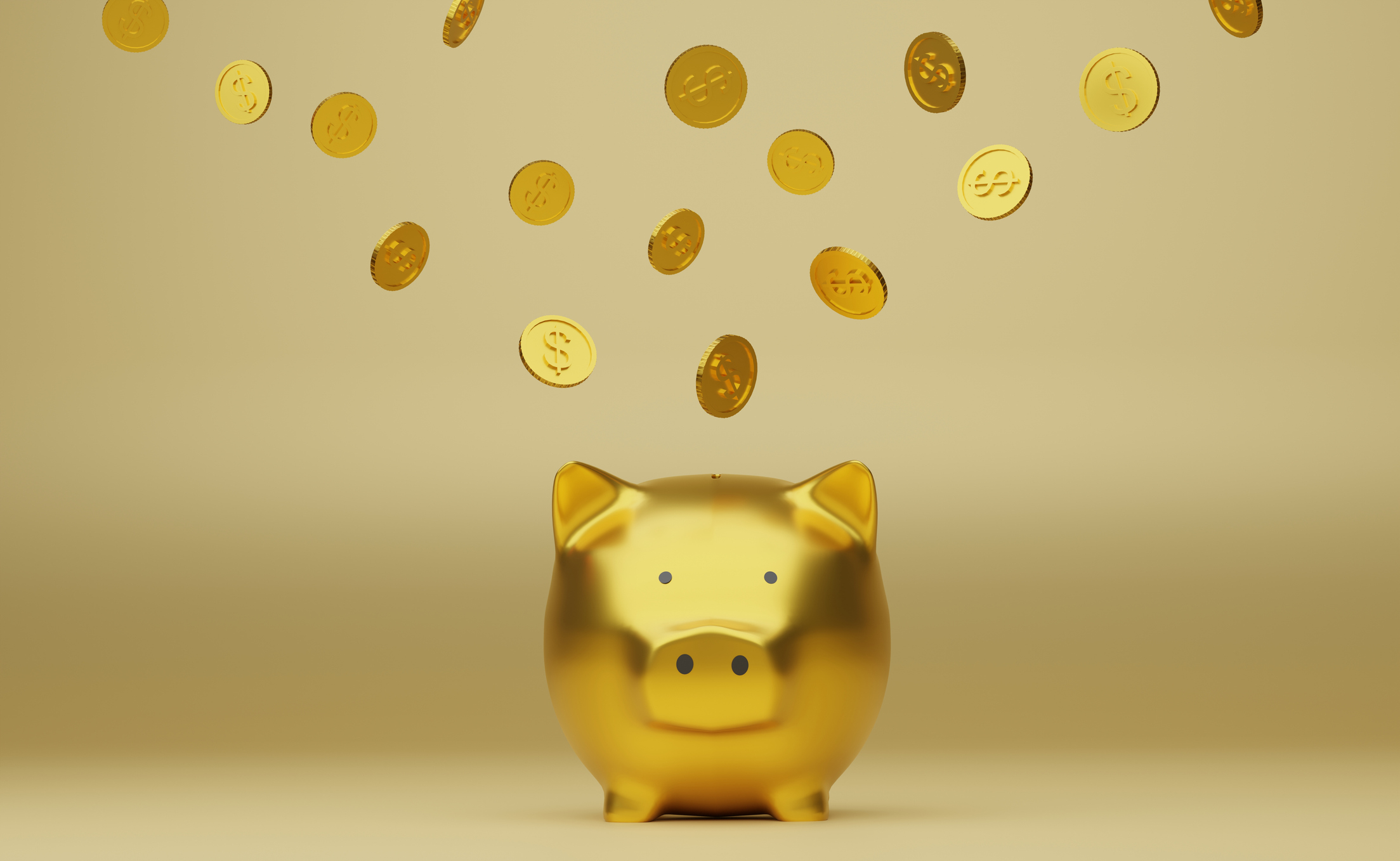 Gold piggy bank with coins falling into it, symbolizing saving money or investment